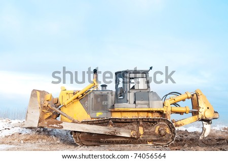 Heavy bulldozer loader at winter frozen soil ripping, moving and excavation works in sandpit