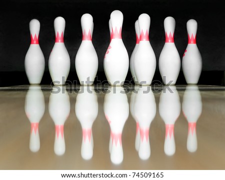 white pins standing on bowling lane before strike
