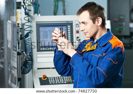 mechanical technician checking cutting detail after cnc milling machine center at tool workshop