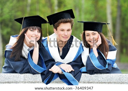 group of three graduation students in the park Ã¢Â?Â? cheerful and happy