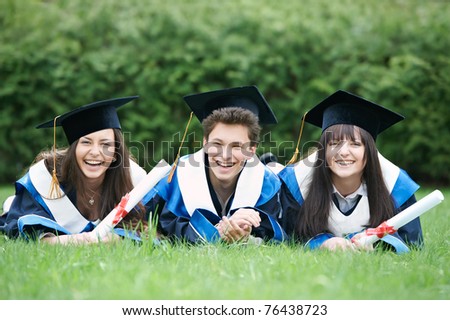 group of three graduation students lying in the park cheerful and happy