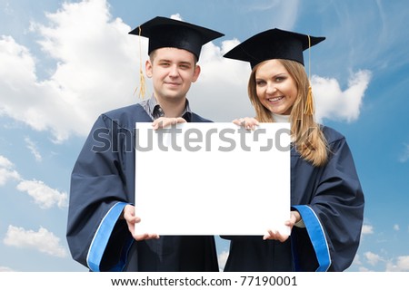 happy graduate students in gown holding white blank card board