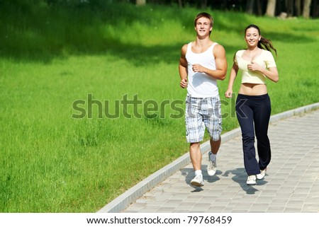 Young fitness couple of man and woman doing jogging sport outdoors
