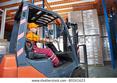Warehouse worker distributing goods in a storehouse with forklift truck loader