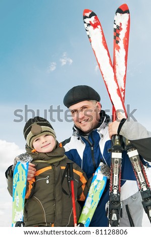 two smiley happy father and child with skis at winter outdoors