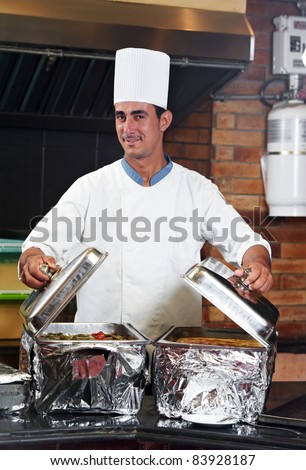 chef man in uniform boiling a soup on cooker in kitchen