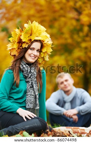 Two Smiling young attractive people with autumn maple leaves in park at fall outdoors date