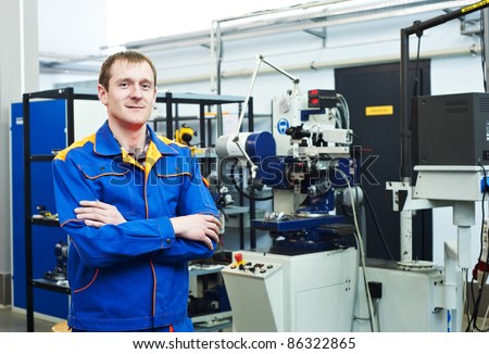 mechanical technician near milling machine at tool workshop