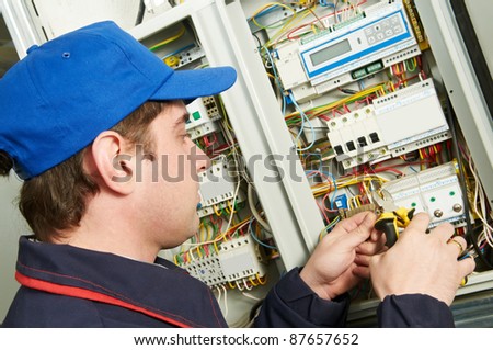 One electrician working on a industrial panel mounting and assembling new wiring