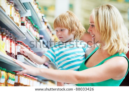 woman and child choosing produces in grocery shopping mall