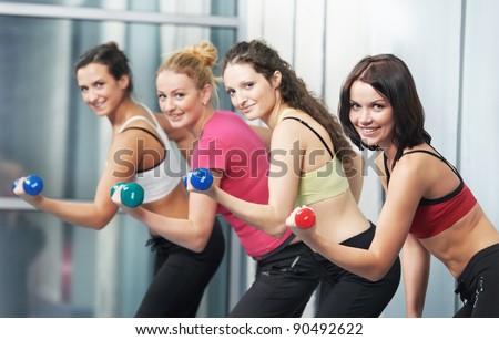 group of woman with dumbbells in gym at fitness physical training exercise in sport wear