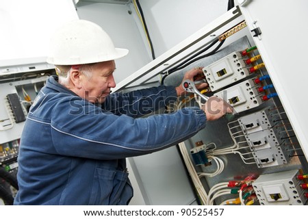 One electrician at work with wrench spanner tighten the screw in electical box