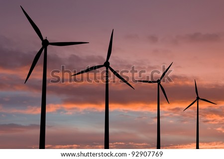 Ecology electric energy farm with wind turbine at sunset