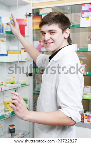 cheerful young pharmacist chemist man working in pharmacy drugstore