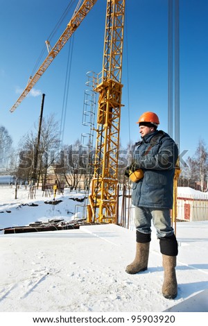 Real worker builder operator with tower crane remote control equipment at construction area site
