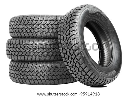 Stack of four wheel new black tyres for winter car driving isolated on white background