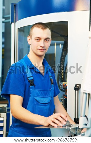 mechanical technician laborer working on modern cnc metal machining milling center in tool manufacturing workshop