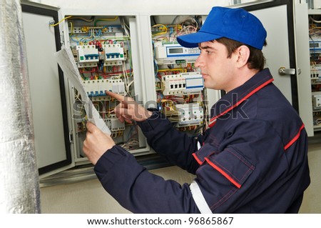 One electrician working on a industrial panel checking and inspecting new wiring at fusebox