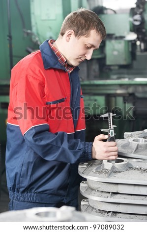 mechanical technician worker measuring detail tool after processing on cutting machine center at workshop