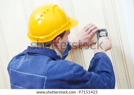 Two electrician workers at wiring cable and light switch or power wall outlet socket installation work