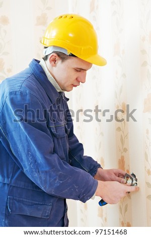 Two electrician workers at wiring cable and light switch or power wall outlet socket installation work