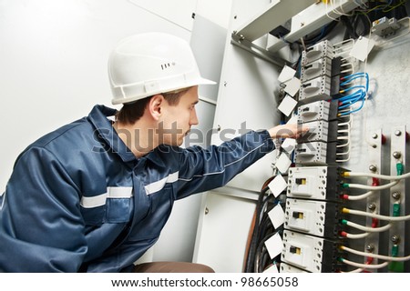 One electrician builder at work inspecting high voltage power electric line distribution fuseboard switching on