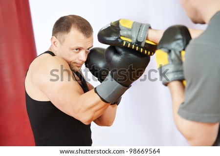 boxer man during boxing hiting mitts at training fitness gym