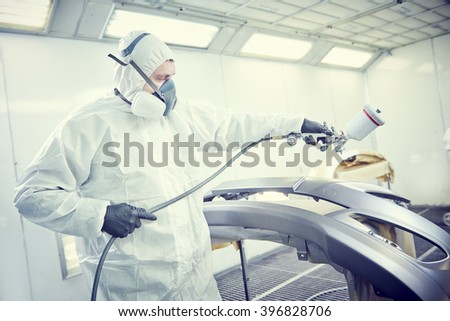 repairman painter in chamber painting automobile car bumper