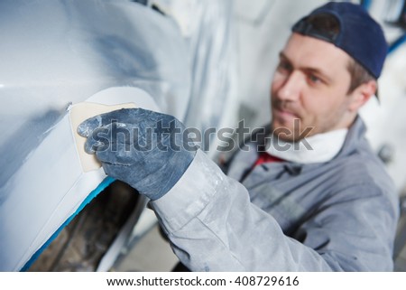 auto repairman plastering autobody bonnet