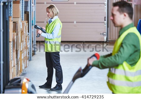 Warehouse Management System. Workers with barcode scanner and stacker