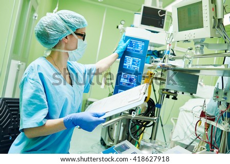 Surgery assistant perfusionist operating a modern heart lung machine