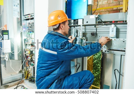 Electrician works with elevator lift equipment