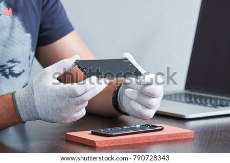 smart phone repair. repairman hands with screen