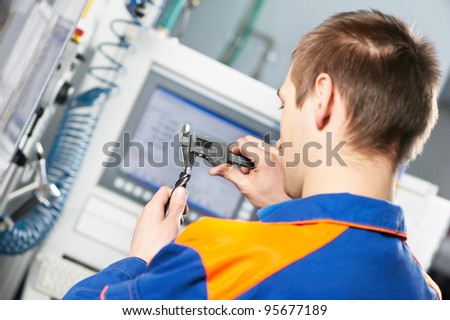 mechanical technician worker measuring detail tool after processing on cutting machine center at workshop