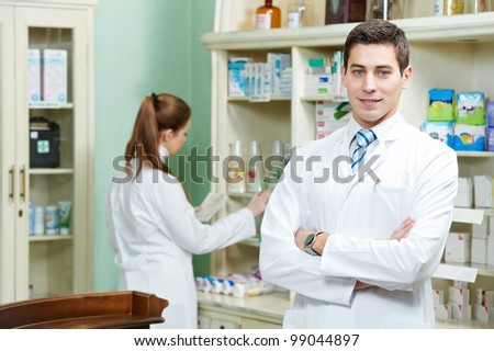 young pharmacist chemist man working in pharmacy drugstore with prescription