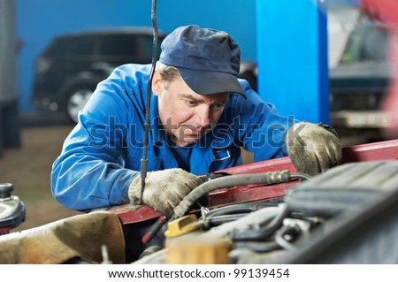 motor mechanic diagnosing automobile car engine before maintenance at repair service station