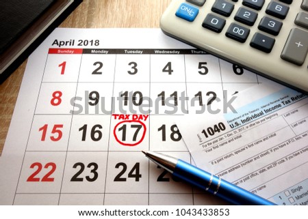 Calendar on office desk showing date April 17 2018 and 1040 form, tax day in USA concept