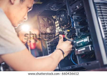 The technician hold the screwdriver for repairing the computer. the concept of computer hardware, repairing, upgrade and technology.