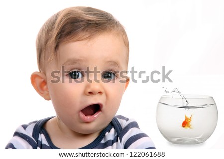 happy baby boy with fish in aquarium
