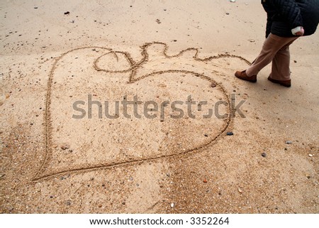 woman drawing a heart in the beach