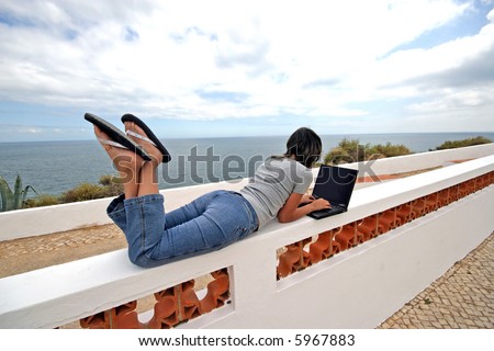 girl working in portable pc in the coast