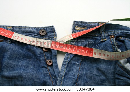 measuring tape around womans trousers, slim photo