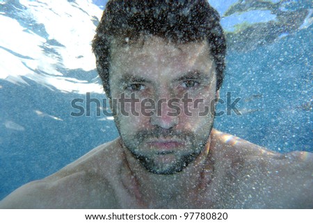 man underwater in the pool, underwater photo, lots of boobles