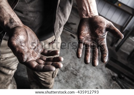 Dirty hands of mechanic at car station