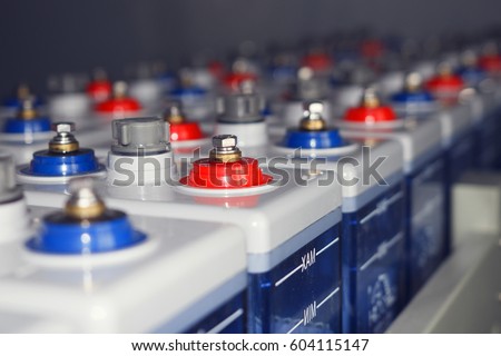 An electric DC battery at an electrical station. A number of powerful batteries. Plus - red and minus - a blue battery or a DC battery.