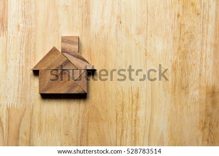 Wooden tangram puzzle in home shape for dream home or happy life concept
