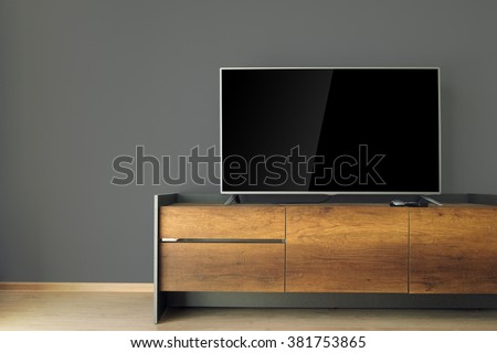 Led TV on TV stand with black wall
