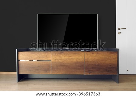 Led TV on TV stand with black wall in the living room