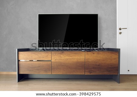 Led TV on TV stand with concrete wall