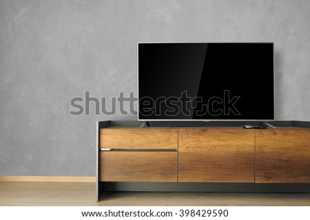 Led TV on TV stand in empty room with concrete wall. decorate in loft style.